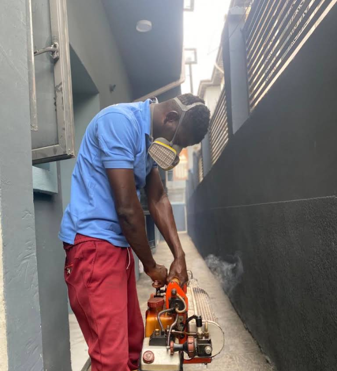 Outdoor fogging treatment along a building walkway in Lagos